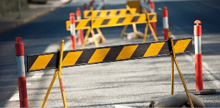 Road construction barriers with black and yellow stripes and red posts