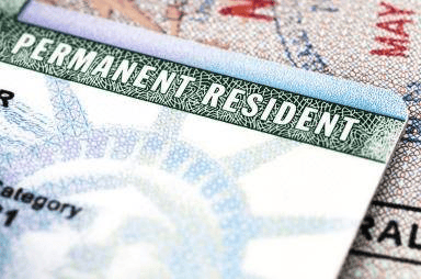 Close-up view of a permanent resident card with a design featuring the Statue of Liberty in the background.
