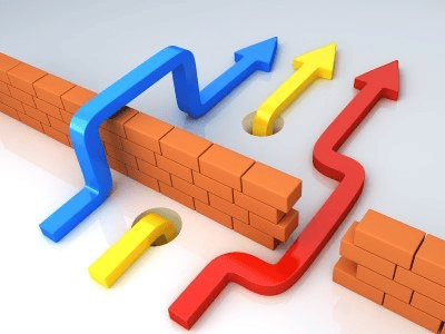 Colorful arrows (blue, yellow, red) navigating through a brick wall, symbolizing overcoming obstacles.