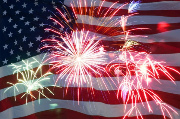 Fireworks exploding in front of an American flag.