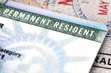 Close-up of a Permanent Resident card on top of a map, highlighting the text 'Permanent Resident'.